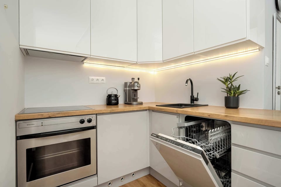 Modern L-shaped kitchen with wooden countertops – Compact yet functional space for meal prep.