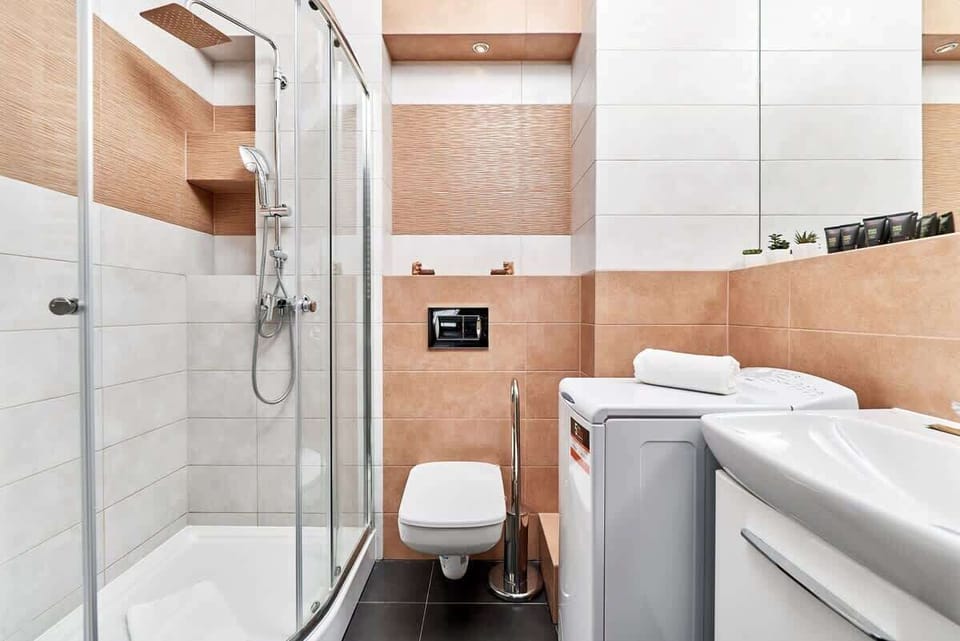 The bathroom's contemporary design includes fresh towels and a hairdryer. 