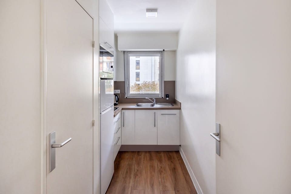 Well equipped kitchen with modern appliances, including a refrigerator, oven, and coffee machine, ideal for preparing your favorite meals.