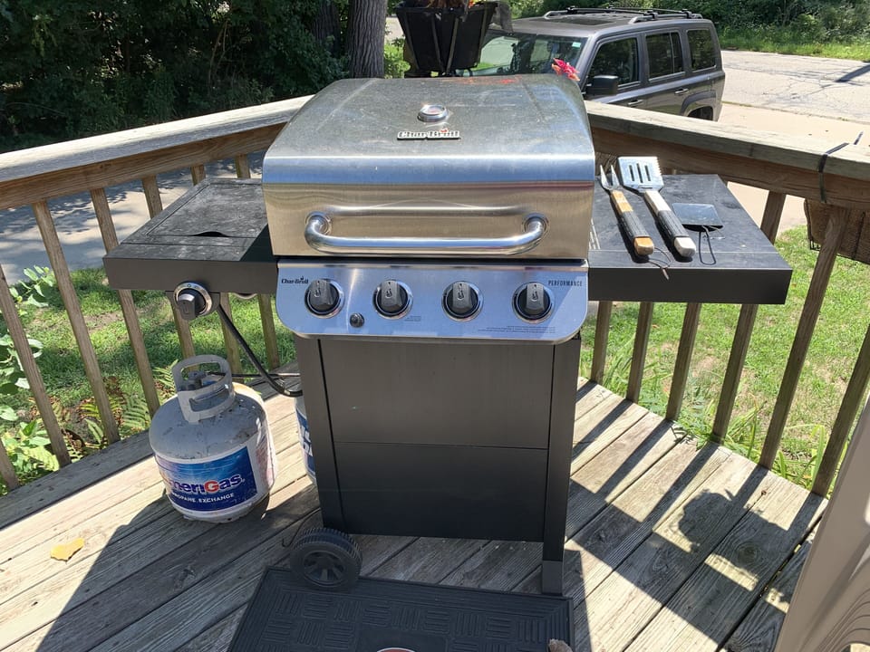 BBQ gas grill with utensils.