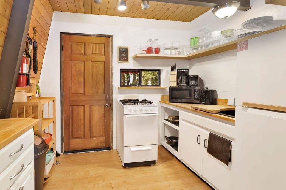 Fully equipped cabin kitchen with ample cabinetry, stove, fridge, microwave, and coffee maker—perfect for cooking meals, morning coffee, and feeling right at home on your stay.