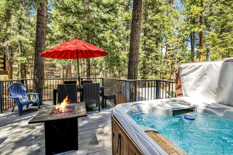 Private outdoor hot tub, surrounded by tall pines, perfect for relaxing under the trees after a day of adventure—enjoy peaceful forest views, fresh air, and a truly rejuvenating stay.