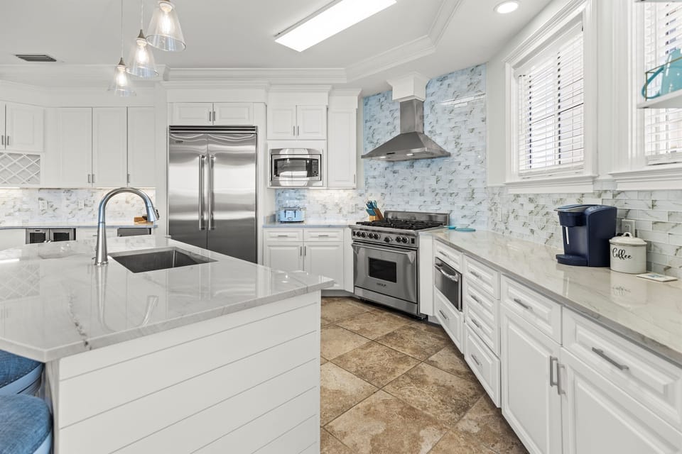 Your gourmet kitchen awaits with gleaming marble countertops, professional stainless appliances, and bright natural light streaming through windows.
