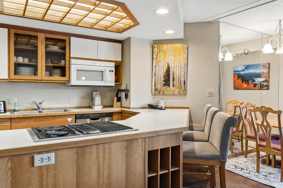 Your fully equipped kitchen awaits with warm wood cabinetry, modern appliances, and a breakfast bar perfect for morning coffee and meal prep.