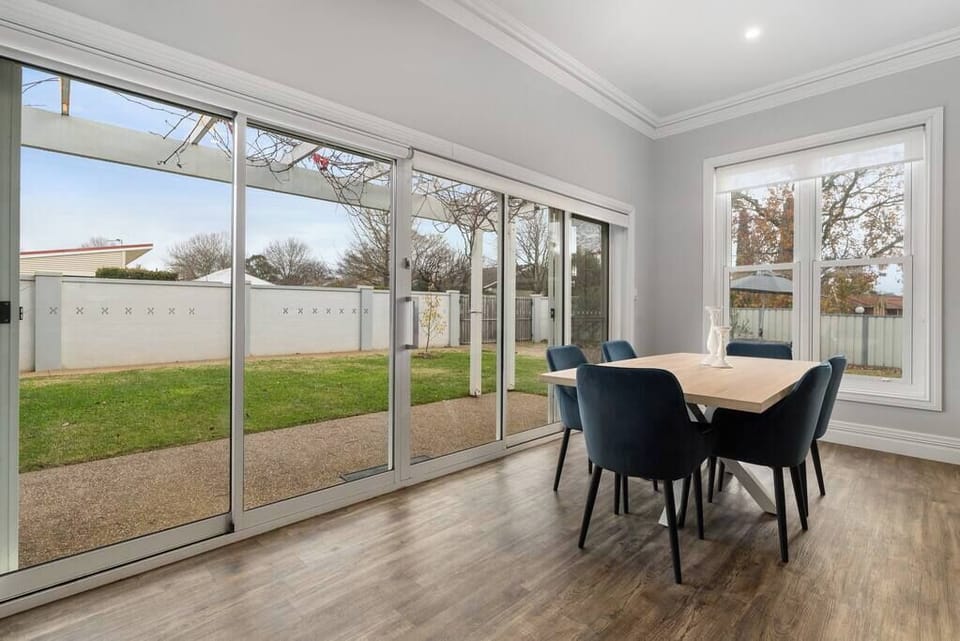 Dining table and large doors to flood the room with light, the vine over the pergola gives filtered light during the warmer months.