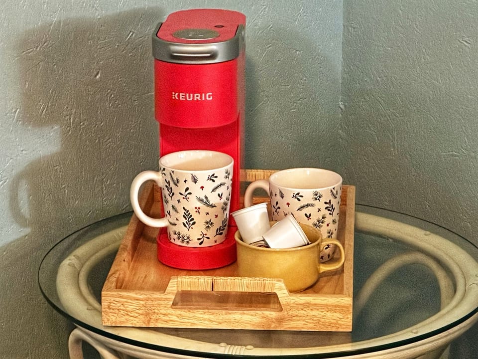 You wake to the soft glow of your electric fireplace, slip from your King bed, and brew a fresh cup just steps away—steam curling up as the room stays hushed and warm - your own private ritual without ever leaving the room