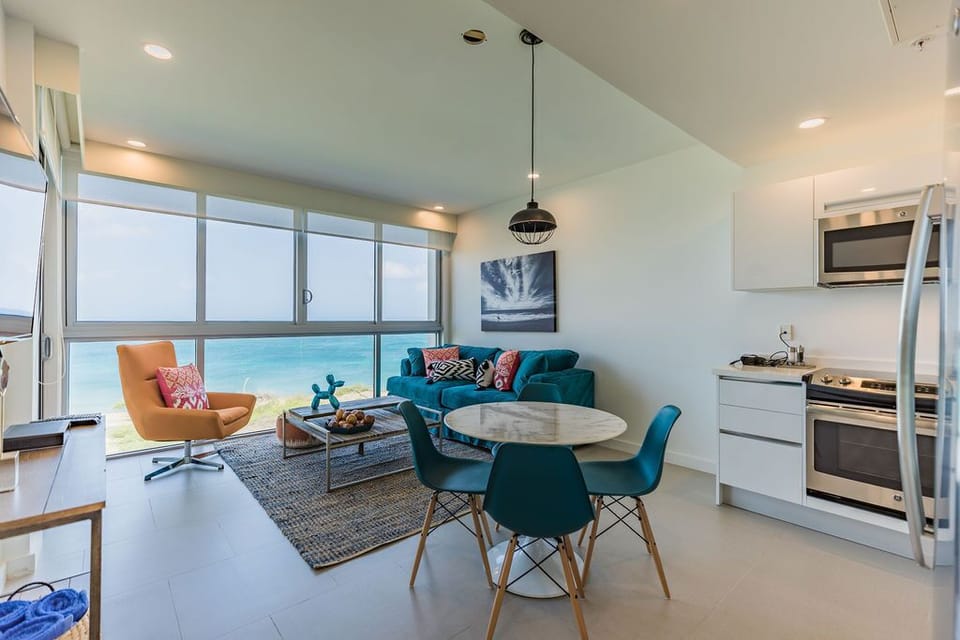 Relax in your modern open-concept space where floor-to-ceiling windows frame stunning ocean views, and stylish furnishings invite you to unwind in seaside comfort.