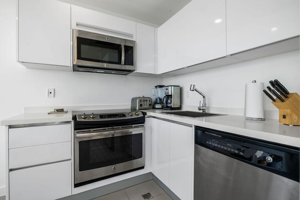 Your fully equipped kitchen features modern stainless steel appliances, crisp white cabinetry, and ample counter space for preparing meals during your stay.