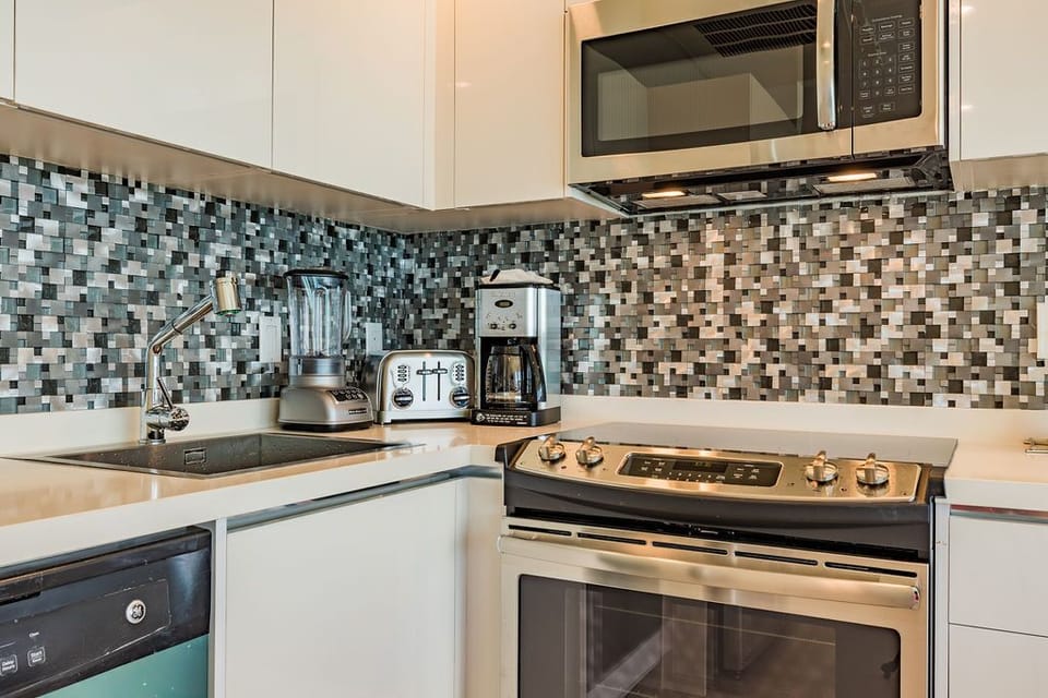 Your modern, fully-equipped kitchen features stainless steel appliances, sleek cabinetry, and a stylish mosaic backsplash—perfect for whipping up meals or your morning coffee during your stay.