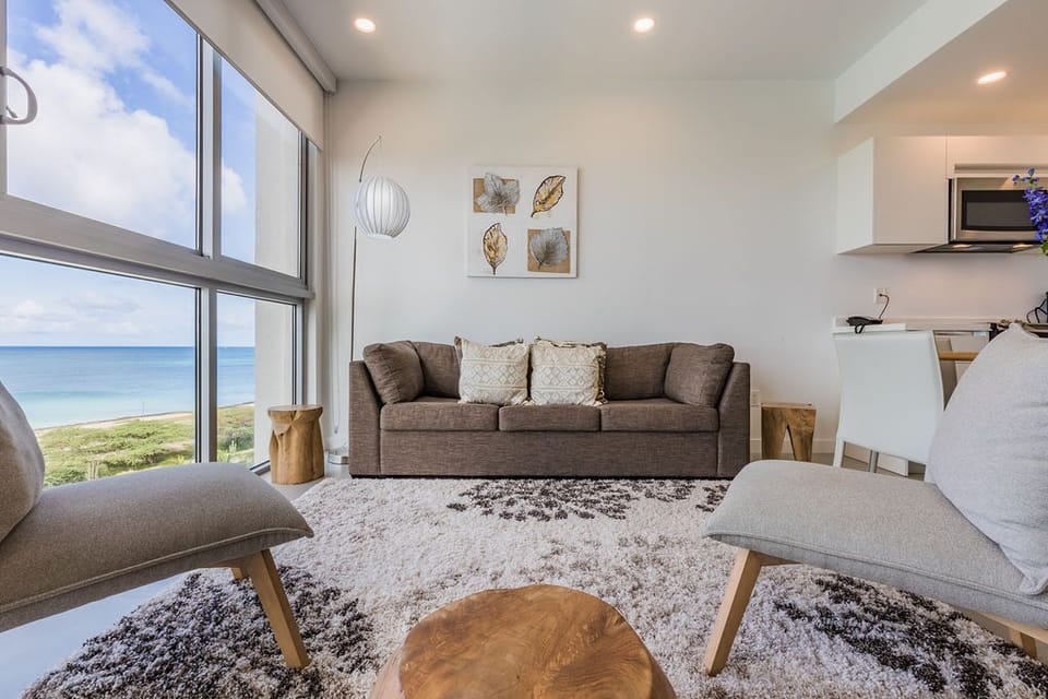 Picture yourself unwinding here, where floor-to-ceiling windows frame stunning ocean views. Soft textures invite relaxation while natural light fills your coastal sanctuary, making every moment feel like a dream escape.