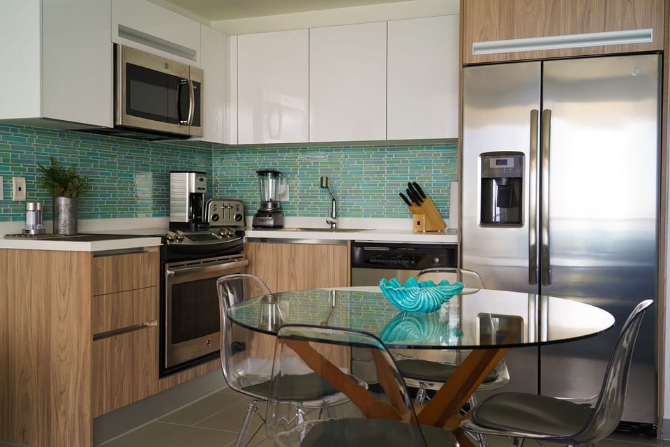 Your modern kitchen features sleek stainless steel appliances, stylish glass tile backsplash, and a charming dining nook—perfect for preparing meals and enjoying breakfast together during your stay.