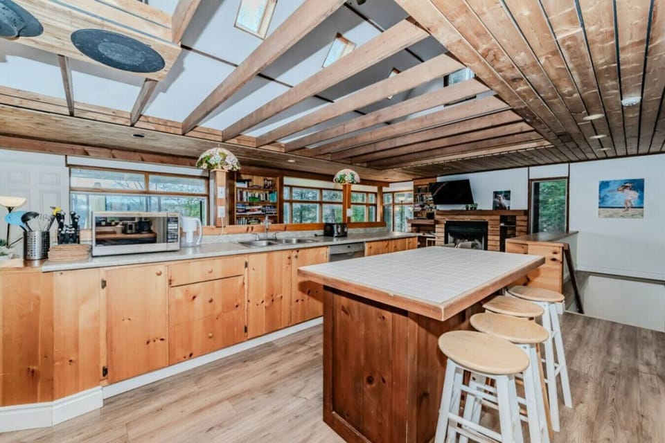 KIT - Our kitchen offers a picturesque view of the dining area and the waterfront, where you can watch guests enjoying the dock. Perfect for keeping an eye on the outdoor activities while you cook
