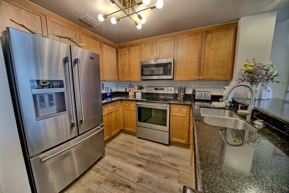 Your fully equipped kitchen features stainless steel appliances, granite countertops, and warm wood cabinetry for all your culinary needs.
