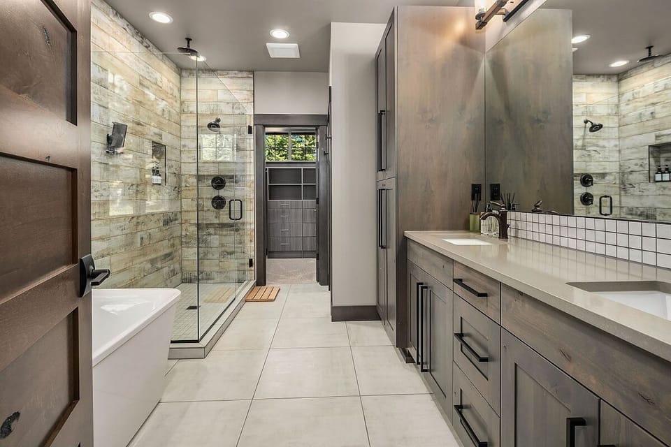 Main Floor – Bathroom 1: Master En-Suite Full Bath with Wide Mirror, Double Sinks, and Designer Lighting.