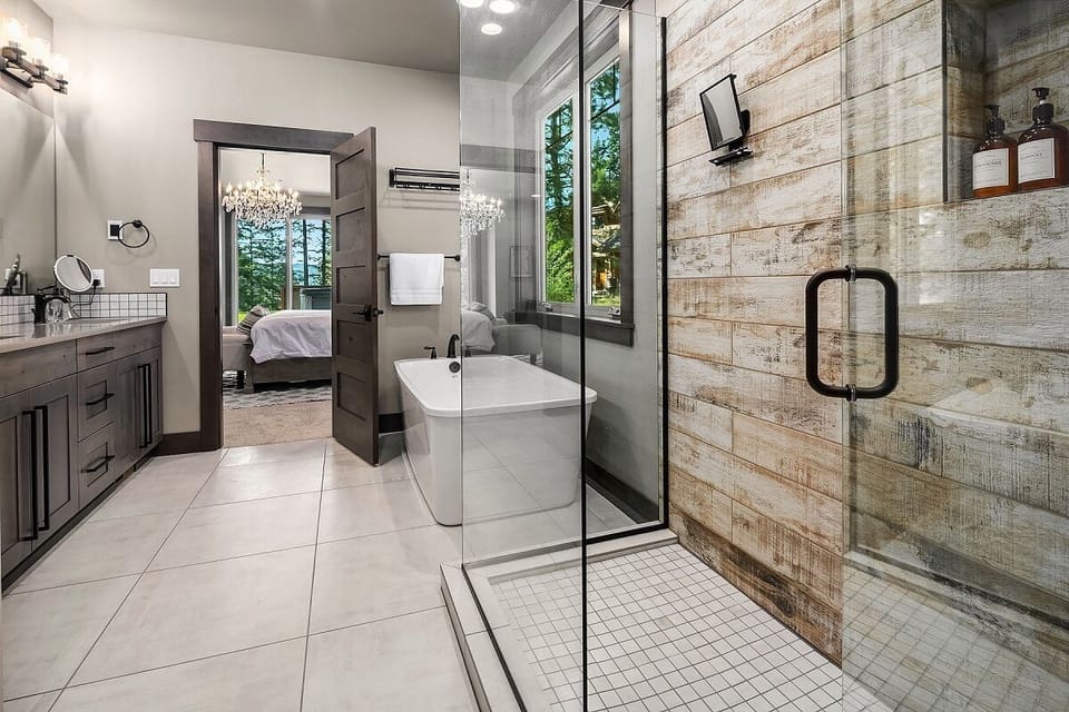 Main Floor – Bathroom 1: Master En-Suite with Walk-In Shower, Soaking Tub, Dual Vanities, and Spa Tile Accents.
