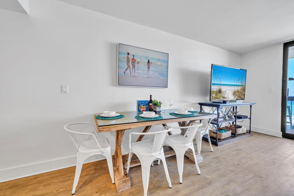 Enjoy meals in your bright dining area with coastal artwork and modern furnishings that create a relaxing beachside atmosphere.