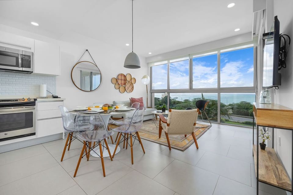 Relax in your bright, open living space where floor-to-ceiling windows frame stunning ocean views. Modern touches meet coastal comfort, creating the perfect backdrop for memorable moments during your stay.