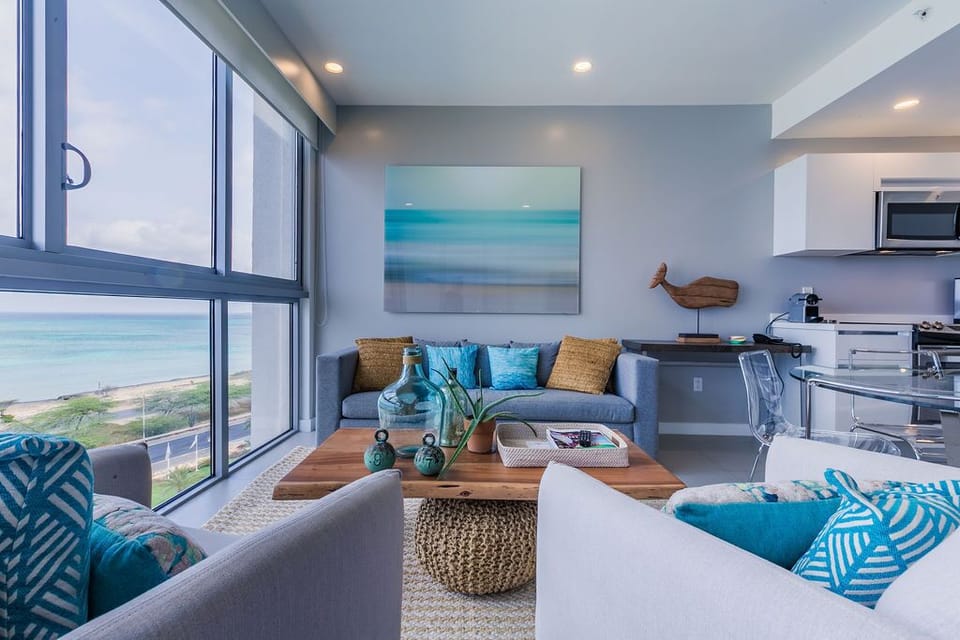 Picture yourself relaxing in this bright, beach-inspired living space with stunning coastal views right outside your window. The soothing color palette and comfortable seating invite you to unwind in style.