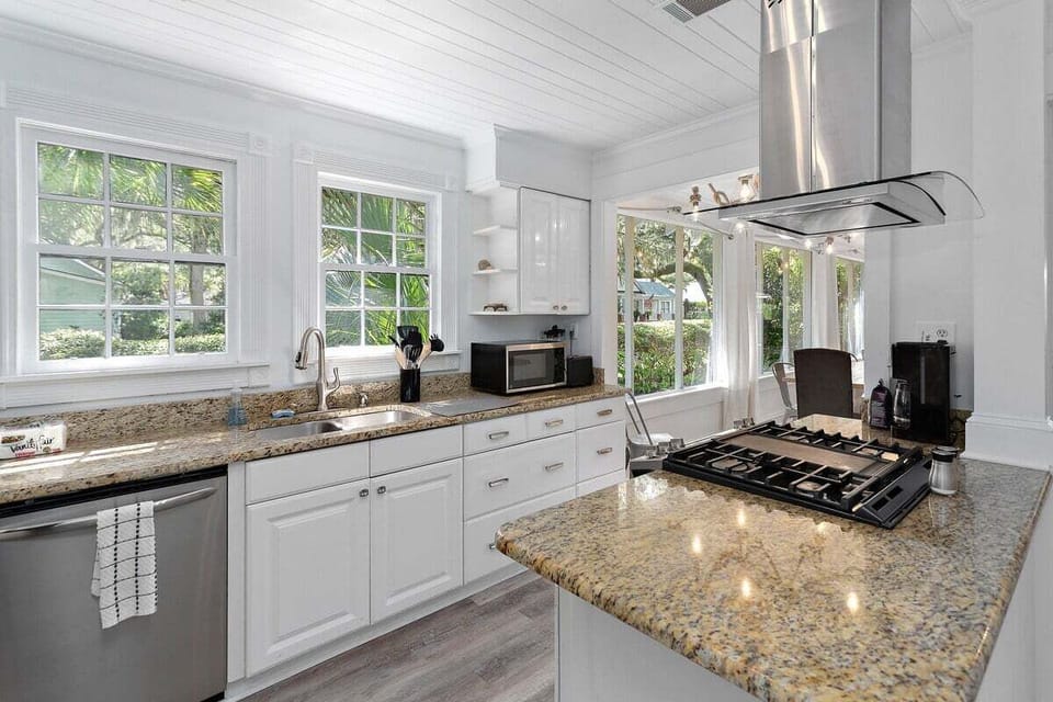 White kitchen with granite countertops and garden window