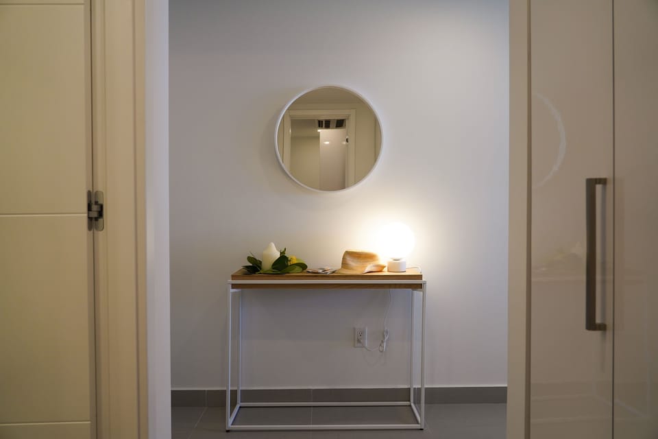 Your entry welcomes you with a minimalist console and round mirror, creating a bright and inviting first impression of your rental retreat.