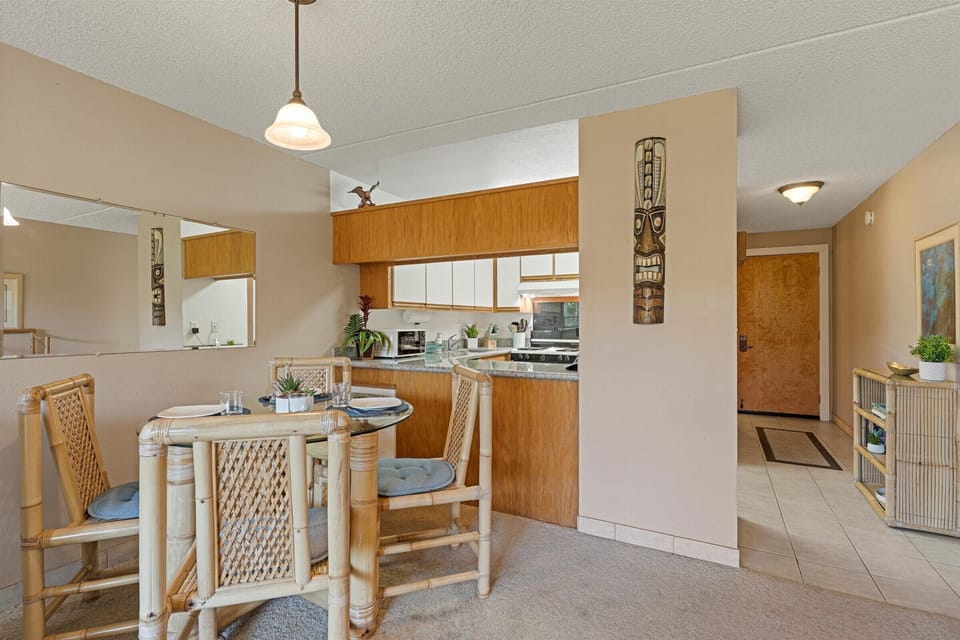 Your open-concept kitchen and dining space welcomes you with warm wood tones and tropical charm, perfect for enjoying meals together at the cozy table for four.