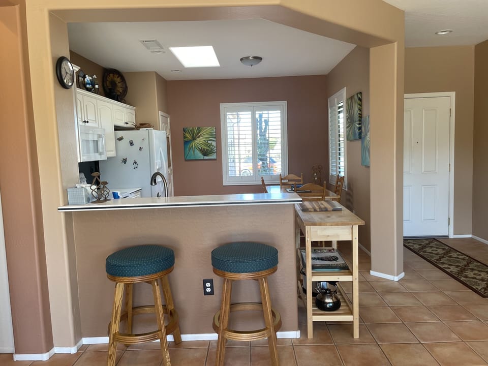 View into eat in kitchen with serving bar and comfy seating.