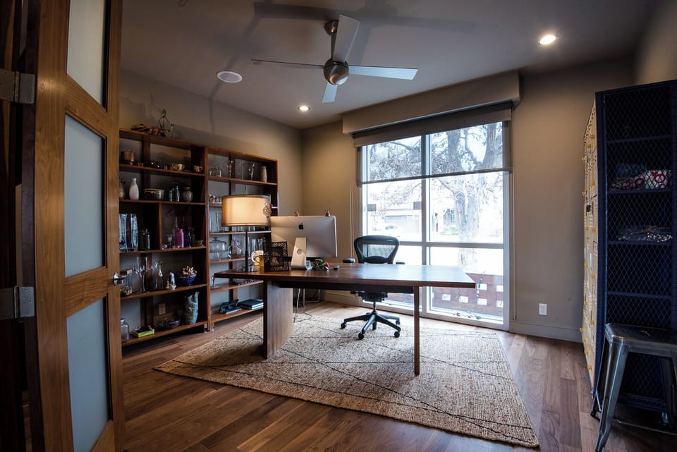 Private office workspace with a large desk, printer, ergonomic chair