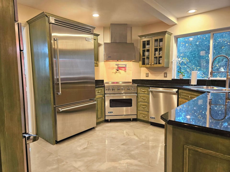 Large built in fridge and induction range with commerical infrared hood.
