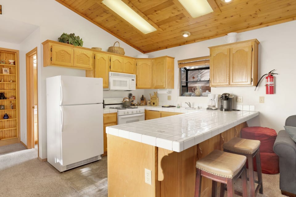 Fully equipped cabin kitchen with ample cabinetry, stove, fridge, microwave, and coffee maker—perfect for cooking meals, morning coffee, and feeling right at home on your stay.