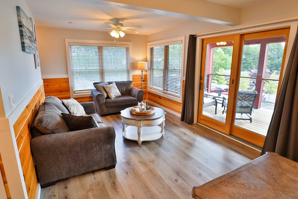 Spacious living room with a pull-out sofa bed and a sliding glass door.