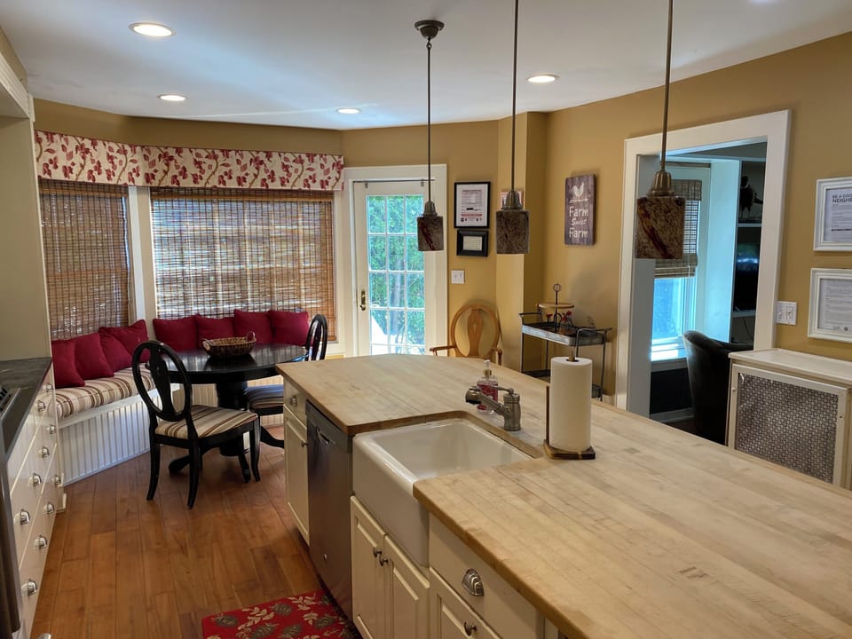 Large kitchen with butcher block counters, farm sink, gas stove, and fridge. 