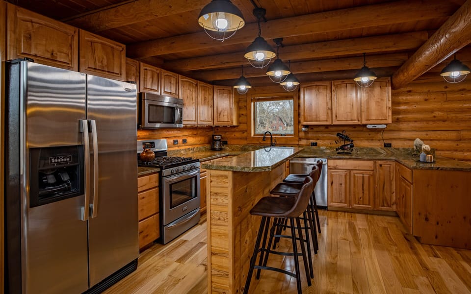 Kitchen with stainless steel appliances and bar seating for 3