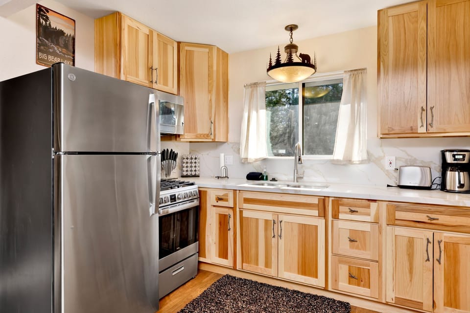 Fully equipped cabin kitchen with ample cabinetry, stove, fridge, microwave, and coffee maker—perfect for cooking meals, morning coffee, and feeling right at home on your stay.