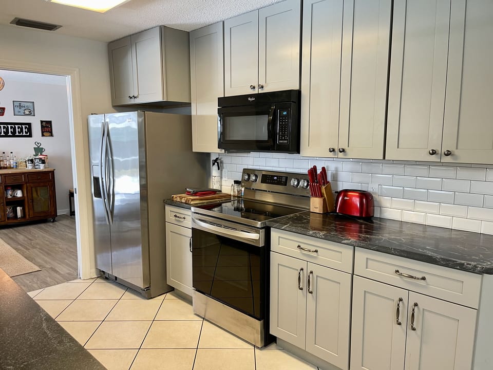 Well appointed kitchen with electric stove, microwave, fridge & ice maker.