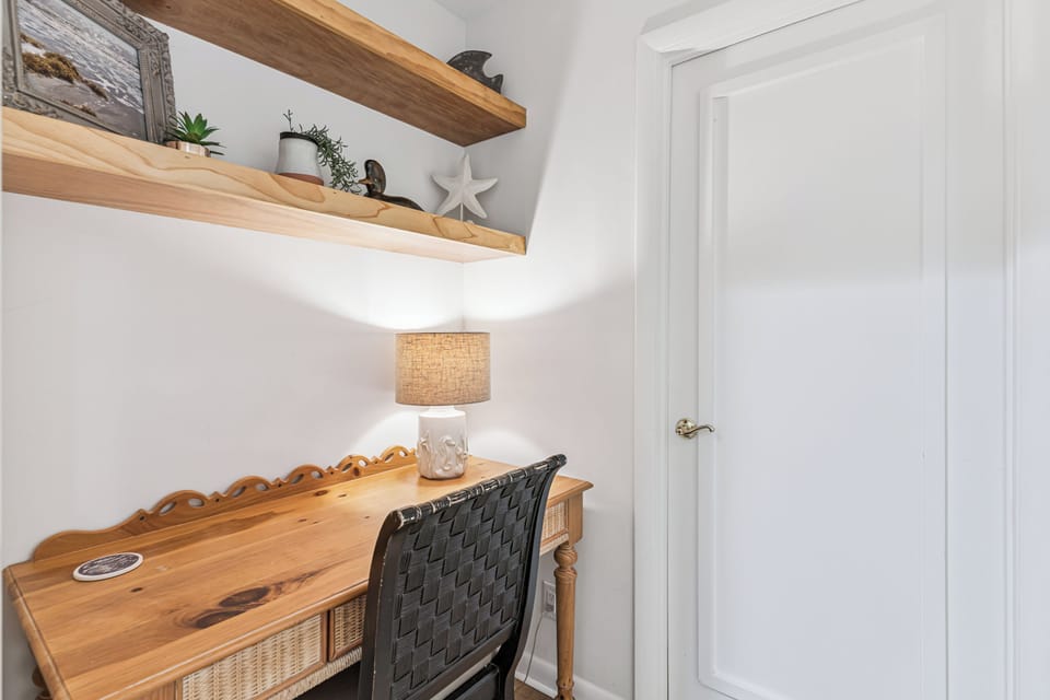 Your own peaceful workspace awaits with warm wood shelving, soft lamp lighting, and coastal touches for inspiration.