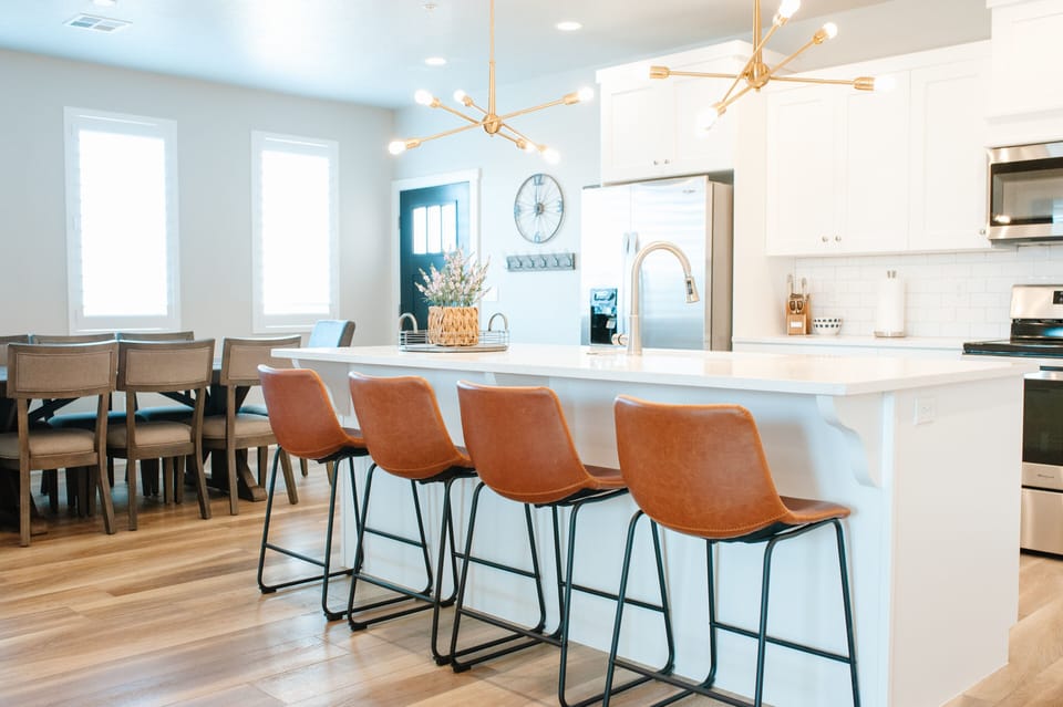 Bright, fully equipped kitchen with bar seating and adjacent dining space for gathering and meals.
