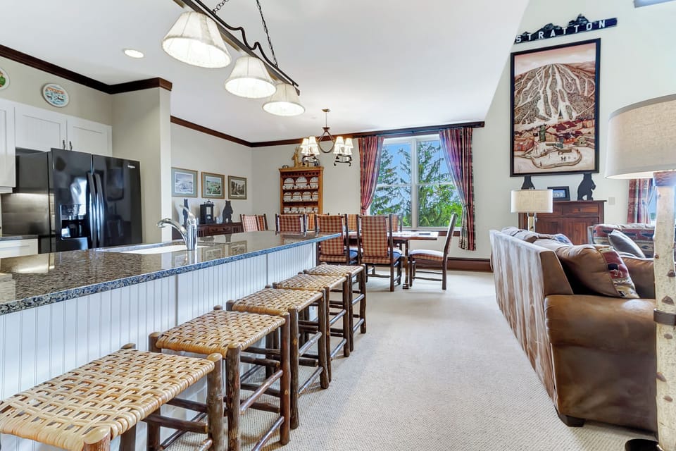 - Open-concept kitchen with granite countertops and rustic bar seating   - Bright living area with mountain charm and warm cabin décor   - Ideal for family meals after a day on Stratton slopes