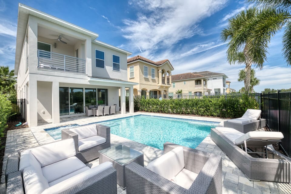 Two cushioned loungers and seating area pool side with deck upstairs