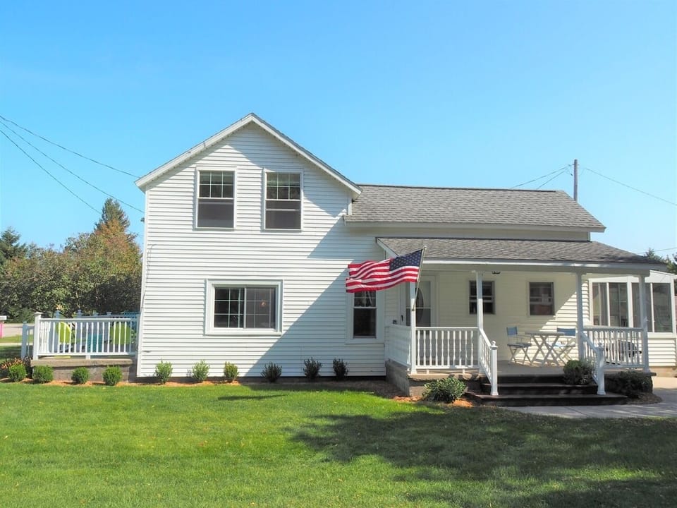 EXTERIOR:  The front of the house in summer.