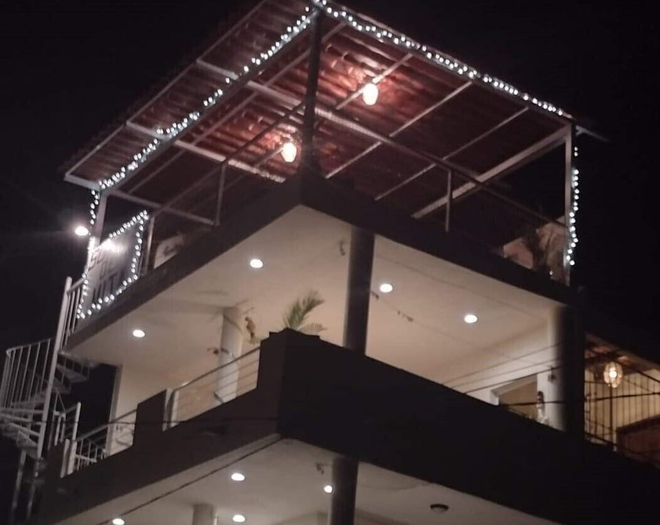 Suites de Mita lighted at night. Top 2 floors are common BBQ palapa areas. 