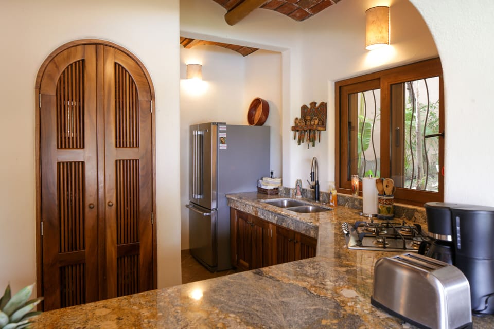 Modern kitchen features granite countertops and gas stove
