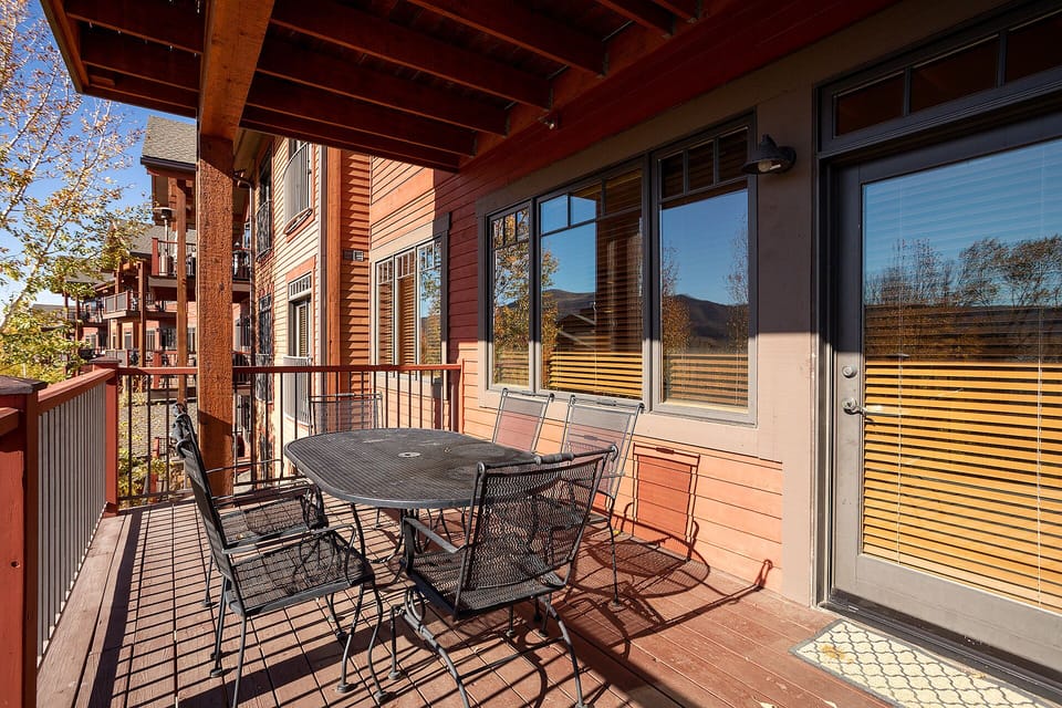 Your private deck offers mountain views and outdoor dining with a cozy table for four under protective beams.