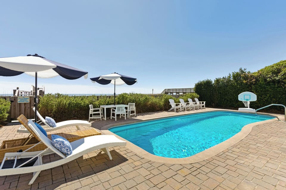 Spacious Pool Deck with Umbrella-Shaded Loungers – Perfect for your Folly Beach getaway.