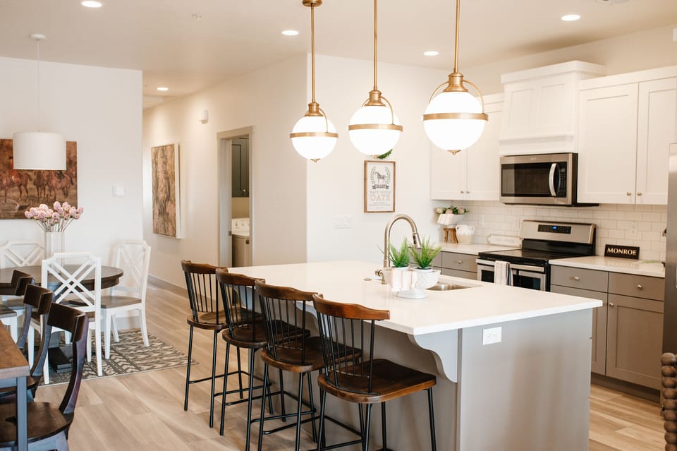 Cook and connect in the modern kitchen with stainless steel appliances, large island seating, and open layout — ideal for family stays near St. George.
