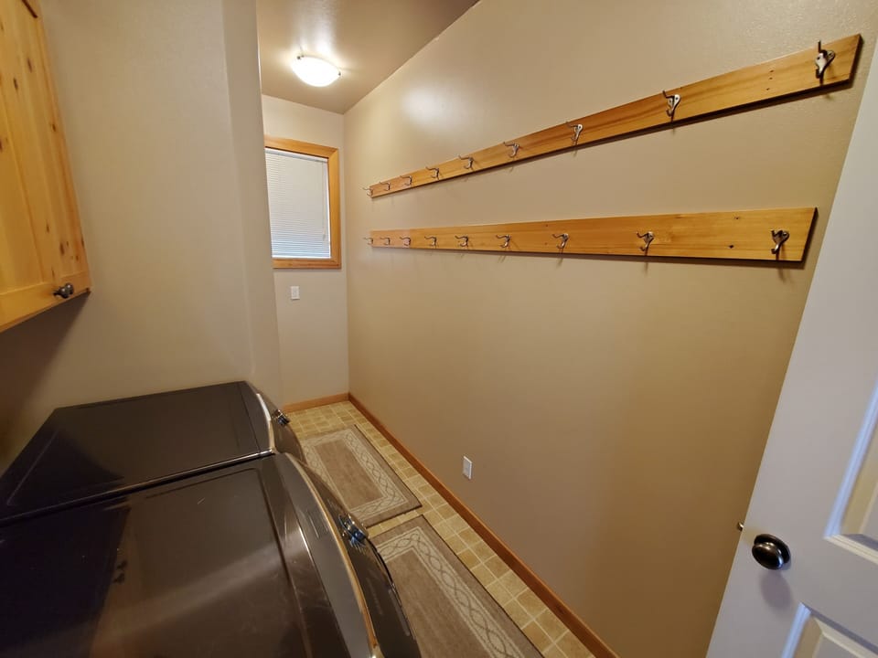 Laundry room has ample hooks for hanging up coats, snow pants, and bags.