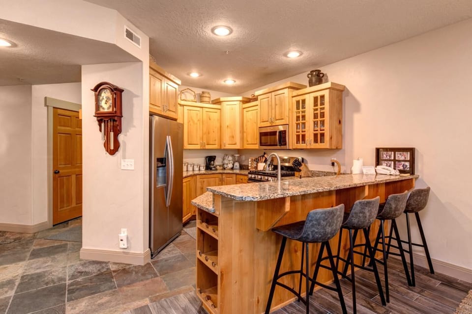 Your fully equipped kitchen includes granite counters, bar seating for four, and custom wood cabinetry with lodge-inspired details.