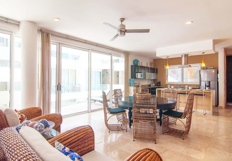 Open dining and kitchen area with floor-to-ceiling doors.