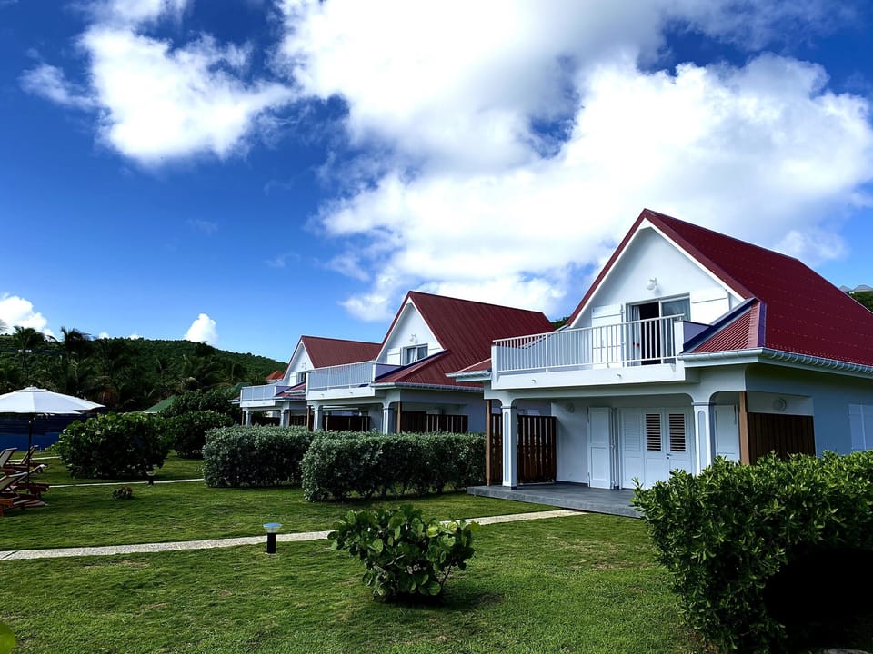 Sea side facades of the three cottages of Sables d'Or on the beach of St Jean in Saint Barth.