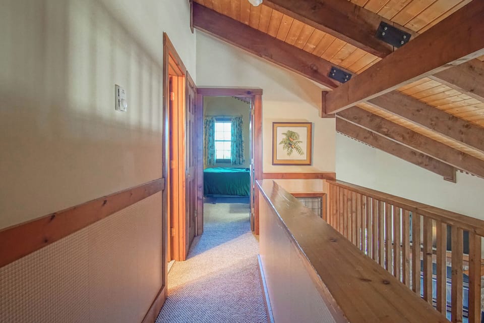 The top of the stairs and the hallway on the top level overlook the living room and dining room.