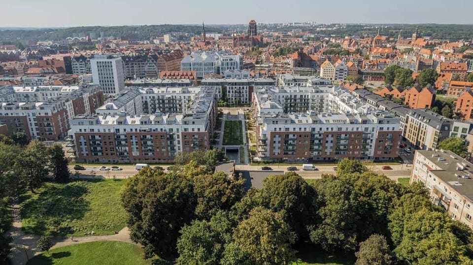 An aerial view of a complex of modern residential buildings surrounded by greenery and landscaping.